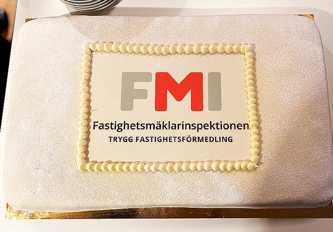 Tårta med FMI:s logotyp och texten Trygg fastighetsförmedling.